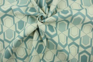  This fabric features a geometric design in gray turquoise and pale beige .