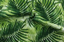 Load image into Gallery viewer, This outdoor fabric features a tropical leaf design in shades of green set against a white background. 

