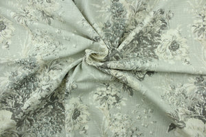  This fabric features a floral design in  gray tones, with white and off white.