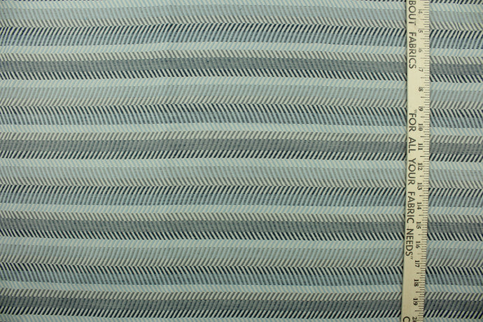  This fabric features a herringbone stripe design in blue and gray tones .