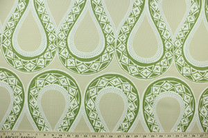 This fabric features a serpentine design in green, gray, white and beige . 