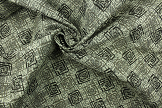  This fabric features a geometric design in  gray, black, taupe and beige with a latex backing.