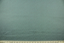 Load image into Gallery viewer, This fabric features a geometric design in gray set against a light turquoise blue with a latex backing. 
