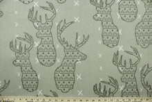 Load image into Gallery viewer, This fabric features a Elk head design in gray and cream set against a beige background with a latex backing.
