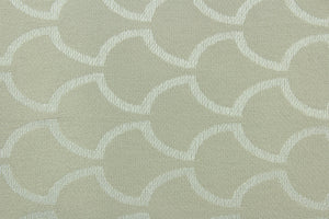 This fabric features a geometric design in shiny beige set against a dull beige .