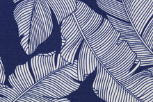 Load image into Gallery viewer, This multi use fabric features a large tropical leaf design in navy blue and white.  It is perfect for outdoor settings or indoors in a sunny room.  It is stain and water resistant and can withstand up to 500 hours of direct sun exposure and has a durability rating of 10,000 double rubs.  Uses include decorative pillows, cushions, chair pads, tote bags and upholstery.
