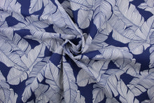 Load image into Gallery viewer, This multi use fabric features a large tropical leaf design in navy blue and white.  It is perfect for outdoor settings or indoors in a sunny room.  It is stain and water resistant and can withstand up to 500 hours of direct sun exposure and has a durability rating of 10,000 double rubs.  Uses include decorative pillows, cushions, chair pads, tote bags and upholstery.
