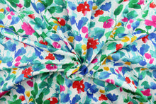 Load image into Gallery viewer, This fabric features a floral design in green, red, blue, turquoise, yellow, and  hot pink against a white background. 
