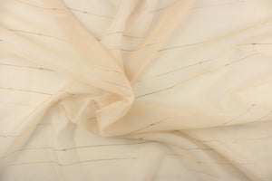 This sheer fabric features a thin stripe design in golden tan, bronze, green, taupe and cream against a light beige .