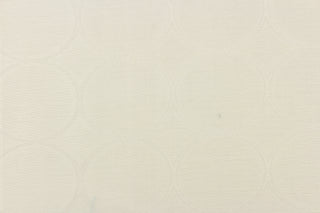  This sheer fabric features a geometric circular design in off white