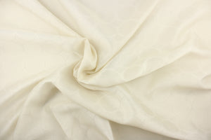  This sheer fabric features a geometric circular design in off white