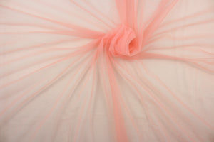 A sheer, light weight, and semi firm tricot in peachy pink .