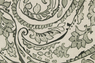 This fabric features a paisley design in  green gray tone set against a natural white . 