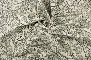 This fabric features a paisley design in  green gray tone set against a natural white . 