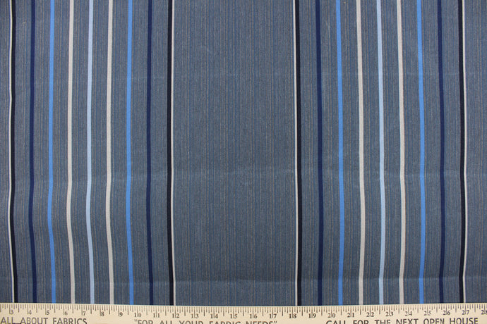 This fabric features a stripe design in varying shades of blue, gray, and black. 