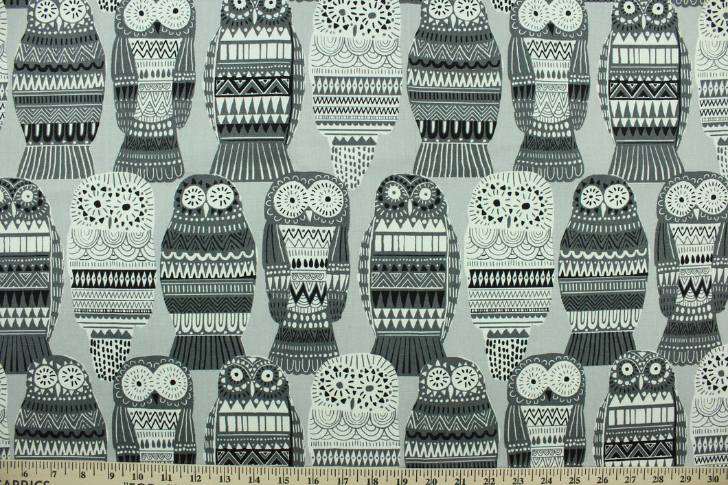  This fabric features an owl design in varying shades of gray and white.