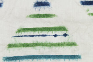 This fabric features a hourglass design in teal, green, dark blue set against a white background .