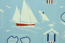 Load image into Gallery viewer, This fabric features nautical design in white, navy blue, and red set against a light blue background. 
