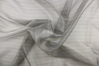This sheer fabric features a stripe design in silver and black with blue undertones . 