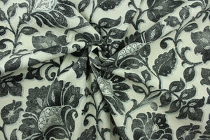 This fabric features a floral design in black, and gray against a pale beige. 