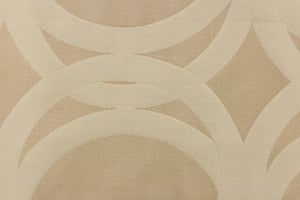 This sheer fabric features a circular design in a beige and nude .