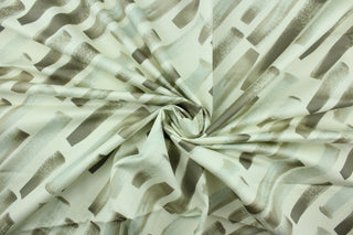 his fabric features a diagonal  broken stripe design in gray, taupe, and white. 