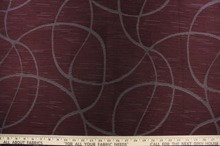  This sheer fabric features a swirl line design in silver against a dark maroon . 