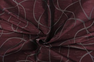  This sheer fabric features a swirl line design in silver against a dark maroon . 