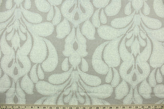 This fabric features a beautiful demask design in silver, and white against a beige background.