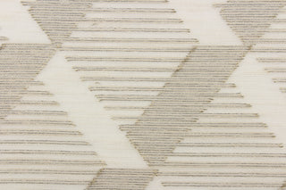 This sheer fabric features a geometric design in gold, gray, and cream against a dull white . 