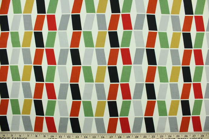 This fabric features a geometric design in black, gray, golden tan, rich orange, green , and red set against a white background.