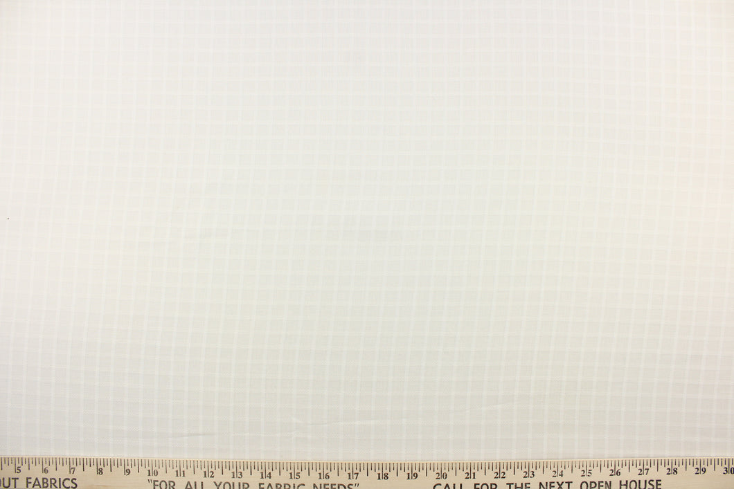  This sheer fabric features a square design in a creamy white .
