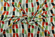Load image into Gallery viewer, This fabric features a geometric design in black, gray, golden tan, rich orange, green , and red set against a white background.

