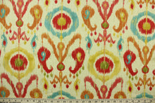 Load image into Gallery viewer,  This printed fabric features an ikat geometric design in  orange, turquoise, rich pink, golden yellow, and olive green,   on a natural background with metallic gold accents.
