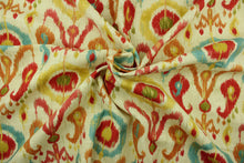 Load image into Gallery viewer,  This printed fabric features an ikat geometric design in  orange, turquoise, rich pink, golden yellow, and olive green,   on a natural background with metallic gold accents.
