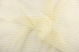 This sheer fabric features a stripe design in gold and cream . 