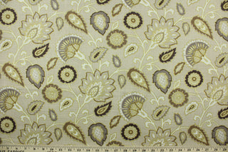  This fabric features a floral design in brown, taupe, beige, and white outline in gold set against a light beige background.
