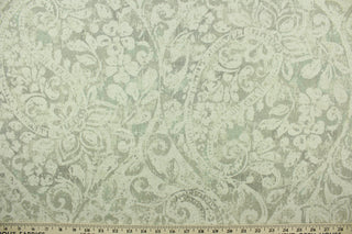 This fabric features a floral paisley design in natural, gray, and light turquoise