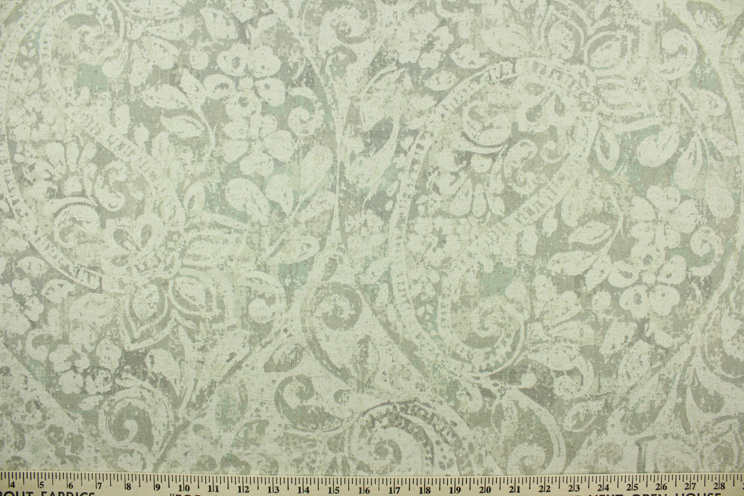 This fabric features a floral paisley design in natural, gray, and light turquoise