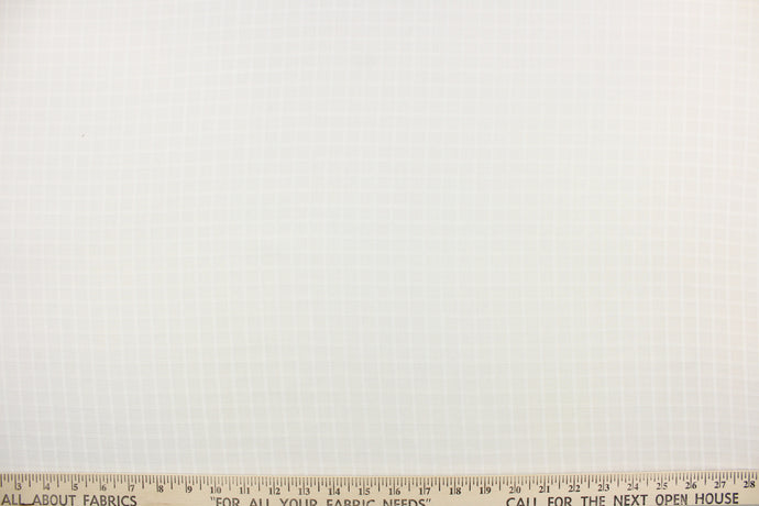 This sheer fabric features a checker design in a off white .