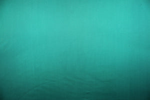 This sheer fabric features a design in a teal green .