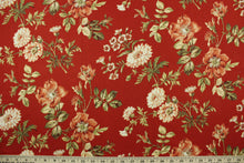 Load image into Gallery viewer, This fabric features a floral design in green, beige, coral, and white set against a red background. 
