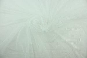 This tulle features a sparkly design in gold set against a white background . 
