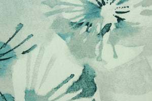  This fabric features a large floral design in shades of blue, with hints of gray set against a white background . 