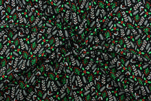 Load image into Gallery viewer, This cotton print fabric features Christmas holly and tinsel.  Colors included are red, white, green and black.  It has a nice soft hand and would be great for quilting, crafting and home décor.  

