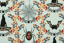 Load image into Gallery viewer, This cotton print fabric features a Halloween design of fall flowers, spiders, bats and witch hats.  It has a nice soft hand and would be great for quilting, crafting and home decor.  
