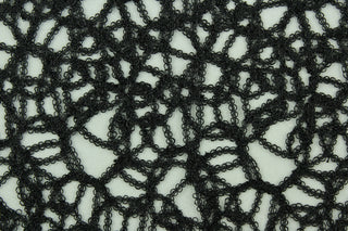 This see through fabric in black features woven mesh lace with metallic black thread and a scalloped border.  It is perfect for special occasion apparel, costumes, overlays, table tops and decorations.  