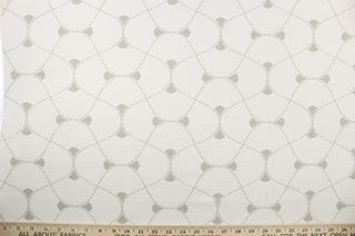 This multi use print fabric in cotton features a large geometrical design in white and gray