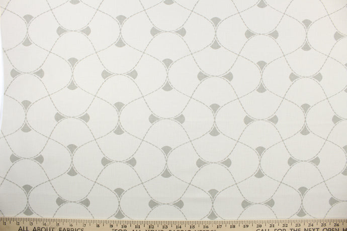 This multi use print fabric in cotton features a large geometrical design in white and gray