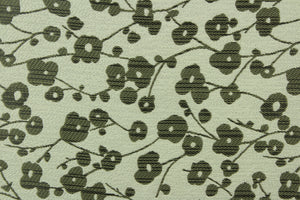 This jacquard fabric features small flowers in dark mauve on a light silver background. 